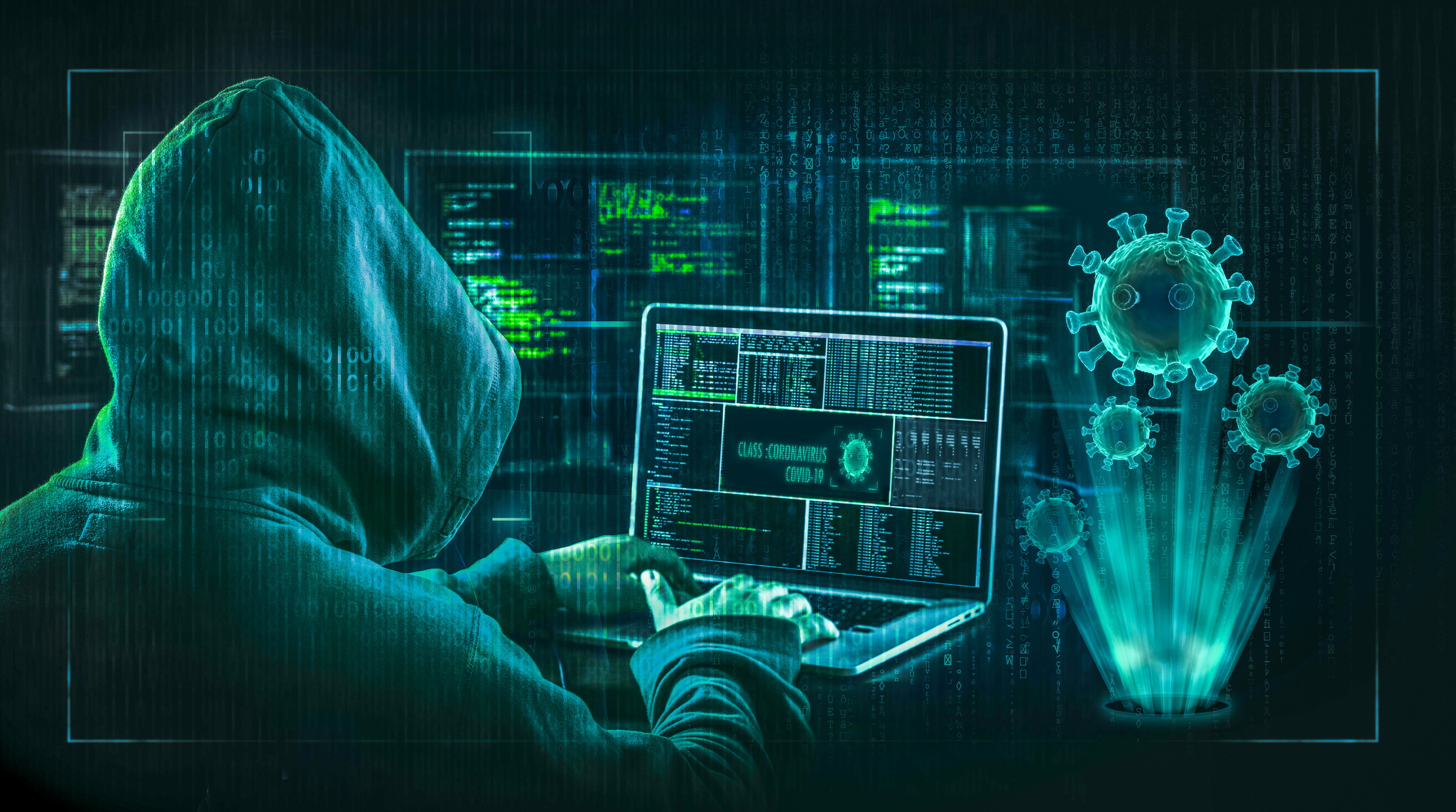 A hacker wearing a hoodie is typing on a laptop.