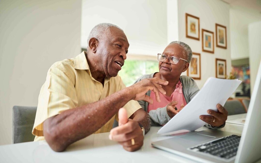 An elderly couple discussing documents.