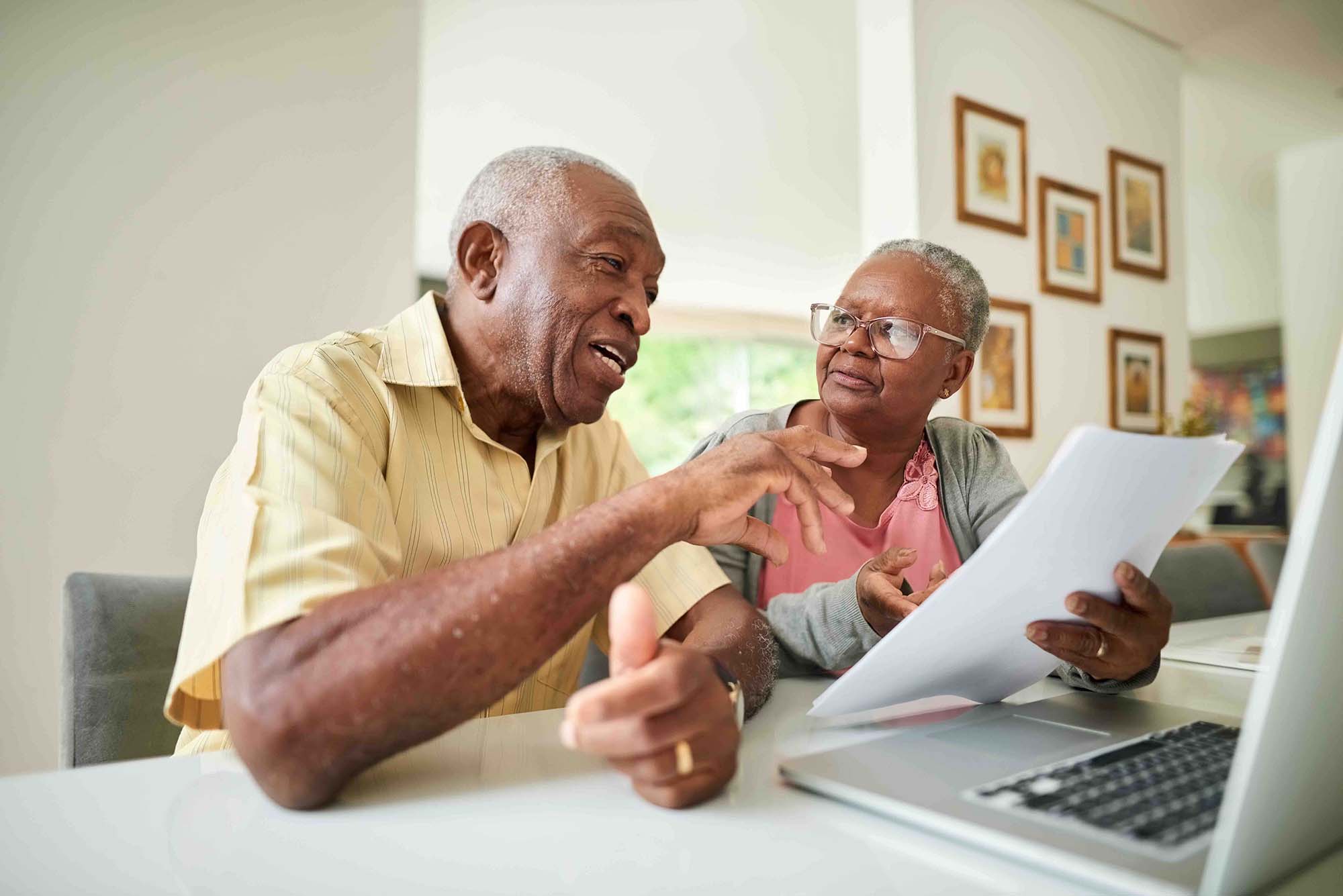 An elderly couple discussing documents.