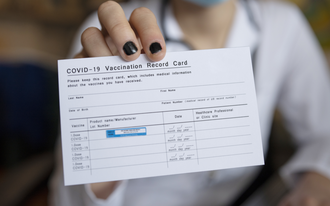 COVID-19 Vaccination Record Card being held by a woman.