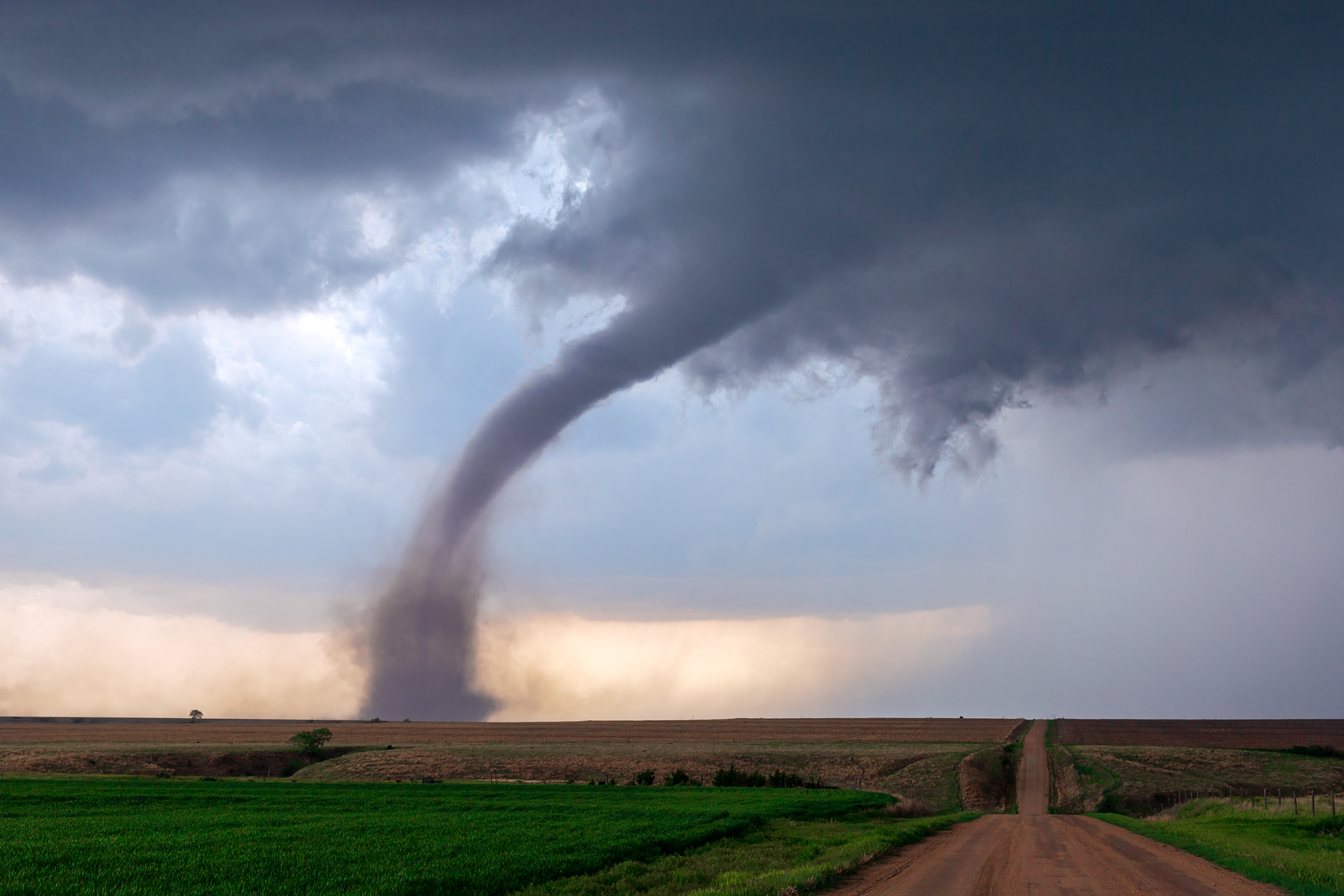 A tornado touching down in a rural farm area.