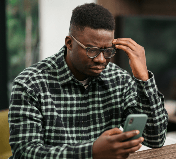 Man looking at his phone afraid he might have been hacked.